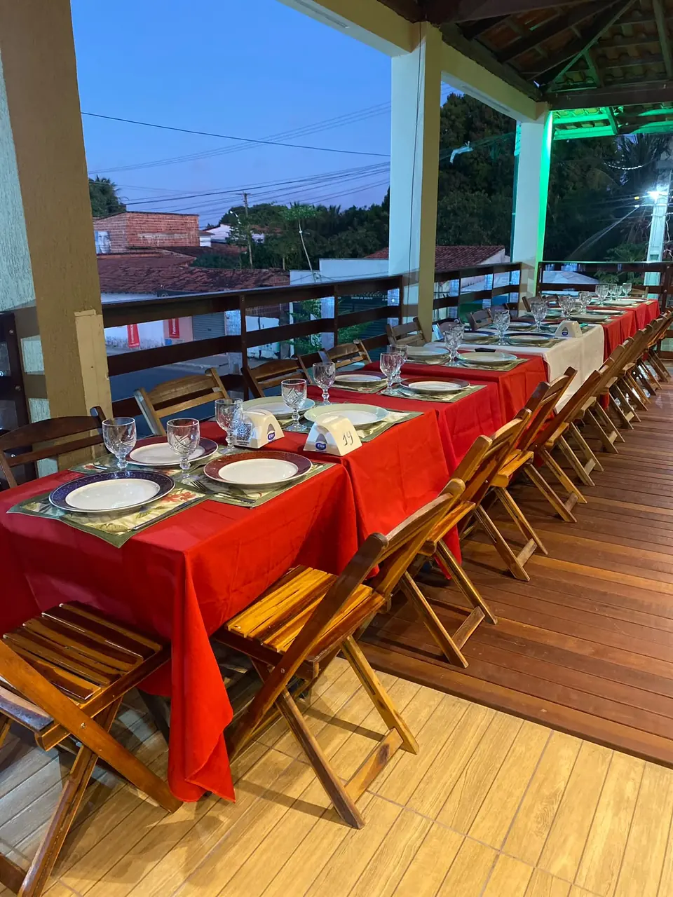 Salão superior do Restaurante e Pizzaria Sr. Bessa, com mesas postas e toalhas vermelhas